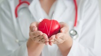 Medical staff hands holding the image of a heart